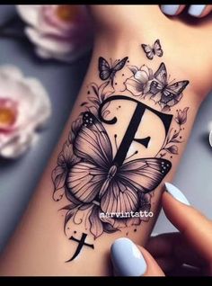 a woman's wrist tattoo with butterflies and the letter f on her left side