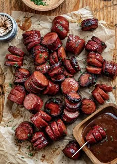 the skewered sausages are ready to be served with dipping sauce on the side