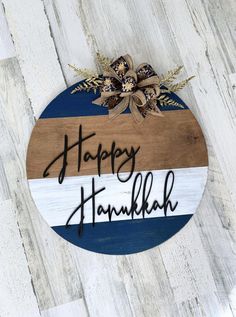 a wooden sign that says happy hanukkah with flowers and leaves on it