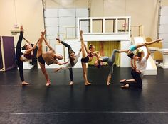 a group of people standing on top of a black floor in front of a stage