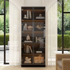 an open book case in the corner of a room with large windows and wicker furniture