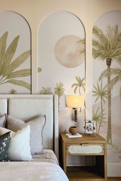 a bedroom with palm trees painted on the walls and bed in front of it, next to a night stand