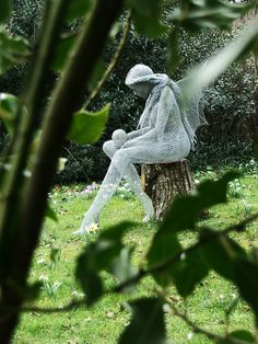 a statue sitting on top of a tree stump