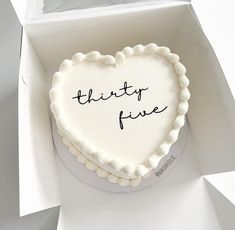 a heart - shaped cake with the words thirty five written on it in a box