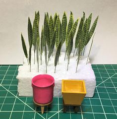 three pots with plants in them sitting on a table