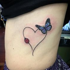 a ladybug and butterfly tattoo on the side of a woman's stomach