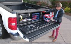 a man loading his truck with tools in the bed and tool box on the back