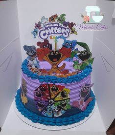 a birthday cake decorated with cartoon characters on the top and bottom tier, in a box