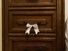 a wooden dresser with white bow on it