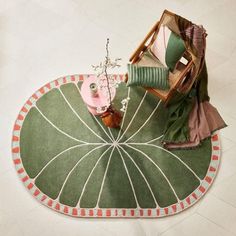 a green rug on the floor with various pieces of furniture sitting on top of it