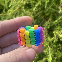 a hand holding several small colorful pieces of plastic