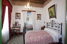 a bed room with a neatly made bed and pictures on the wall