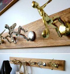 two metal figurines are on a wooden shelf next to a wall mounted art piece