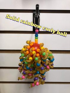 a bunch of beads hanging on the side of a building with words sold rainbow curly ball