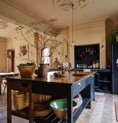 a kitchen island with baskets on it in front of an open doored dining room