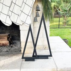 a fireplace with bells hanging from it's sides next to a blanket and tree