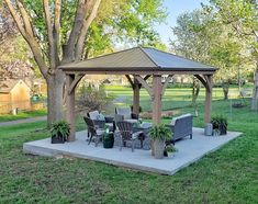 a gazebo sitting on top of a cement slab in the middle of a park