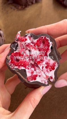 a person holding up a piece of chocolate with cranberry yogurt clusters on it