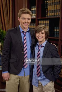 two young men in suits and ties standing next to each other