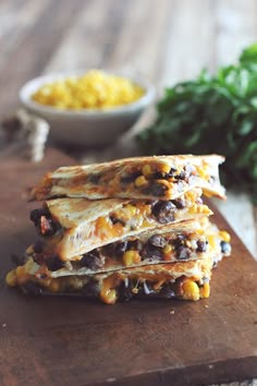 three quesadillas stacked on top of each other with corn in the background