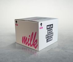 a white box with pink lettering on the side sitting on top of a gray floor