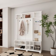 a white coat rack with shoes and umbrellas on it next to a potted plant