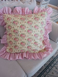 a pink pillow with ruffled edges on a chair