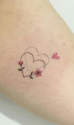 a small heart tattoo with flowers on the side of her arm and an arrow in the shape of a heart