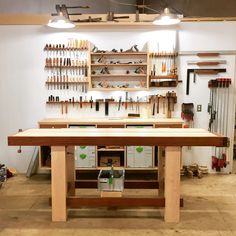 a workbench with lots of tools hanging on the wall