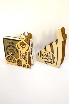 two wooden bookends made to look like shoes with arabic writing on the side