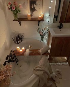 a bathroom with candles and flowers in the bathtub