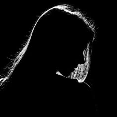 black and white photograph of a woman's face with long hair in the dark