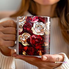 a woman holding a coffee mug with roses on it