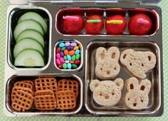 a bento box filled with fruit, pretzels, and other food items