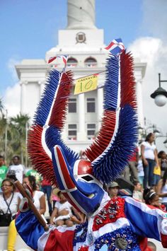 a man in an elaborately decorated costume is holding a baseball bat while people watch