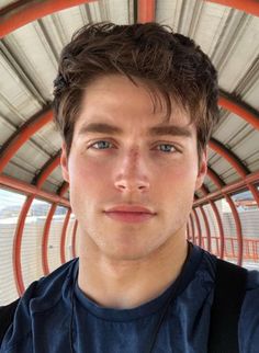 a close up of a person wearing a backpack and looking at the camera with a serious look on his face