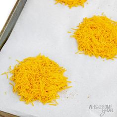 three pieces of shredded cheese are on a baking sheet, ready to go into the oven