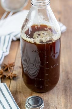 a glass bottle filled with liquid sitting on top of a wooden table