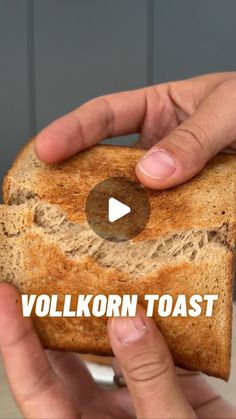 a person holding a piece of bread with the words vollkorn toast on it