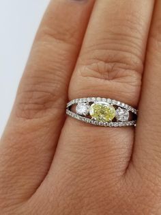 a woman's hand with a yellow and white diamond ring