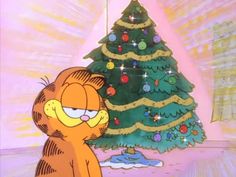 garfield the cat standing in front of a christmas tree