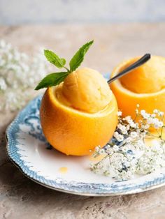 two oranges on a blue and white plate with flowers