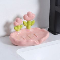 a pink soap dish sitting on top of a white counter