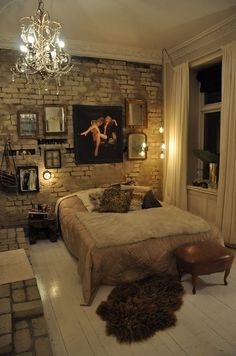 a bed room with a neatly made bed and a chandelier hanging from the ceiling