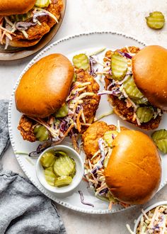 two chicken sliders with pickles and coleslaw slaw on a plate