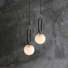 three light fixtures hanging from the ceiling in a room with concrete walls and flooring