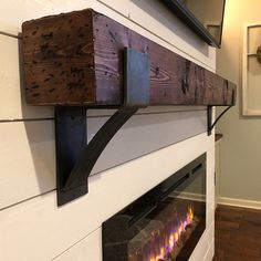 a wall mounted electric fire place in a living room with wood and metal trimming