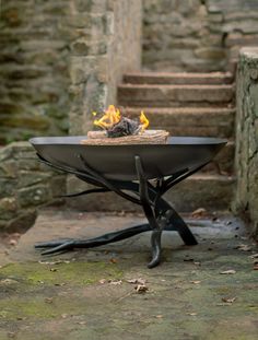 a fire pit sitting on top of a stone walkway