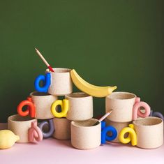 a pile of cups with letters and a banana on top