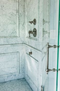 a bathroom with white marble walls and floors